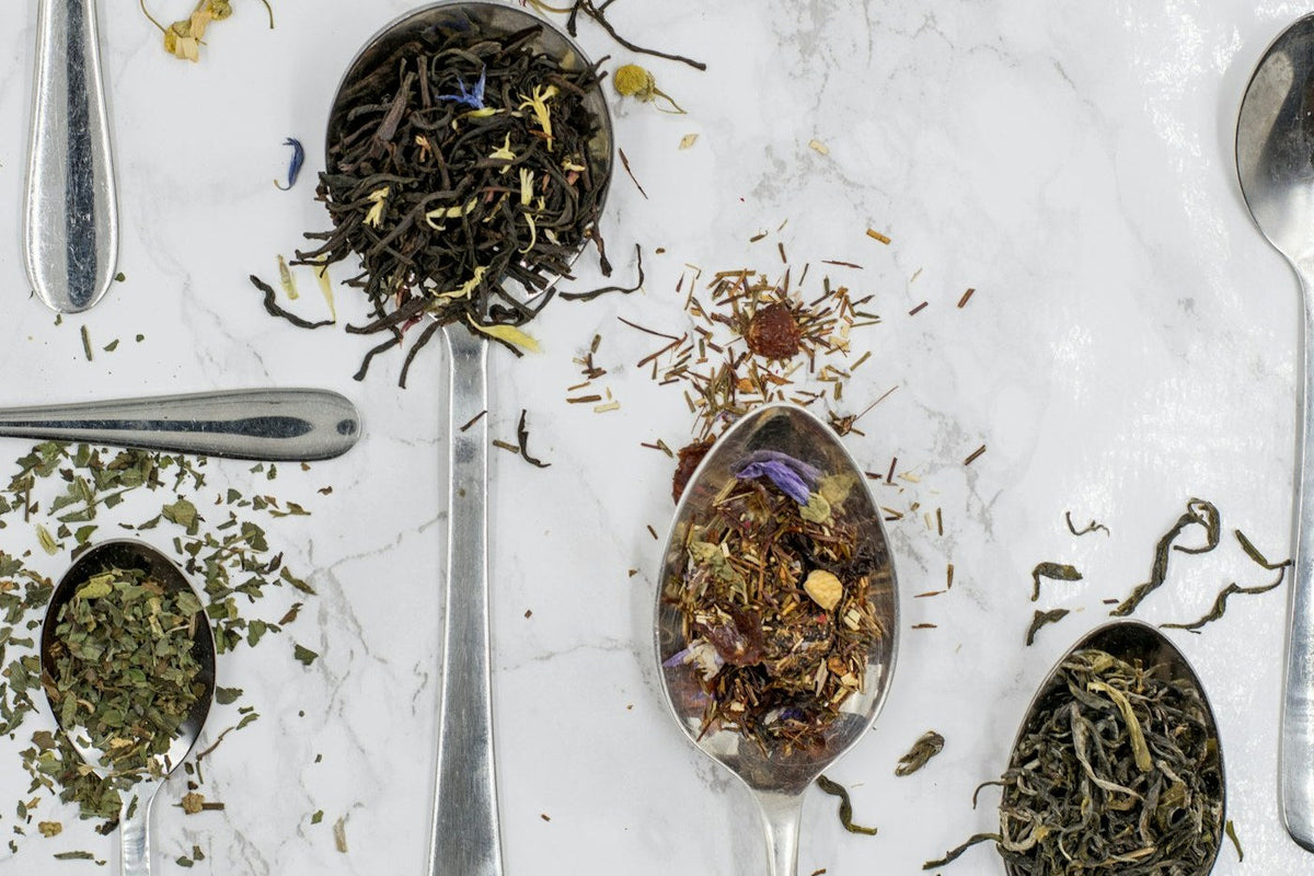 Loose leaf black, green, mint and herbal tea on spoons