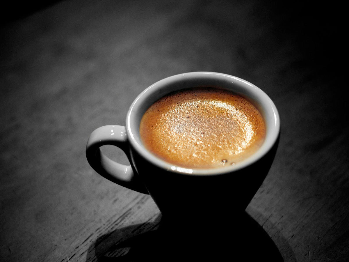 Espresso with crema in a black cup