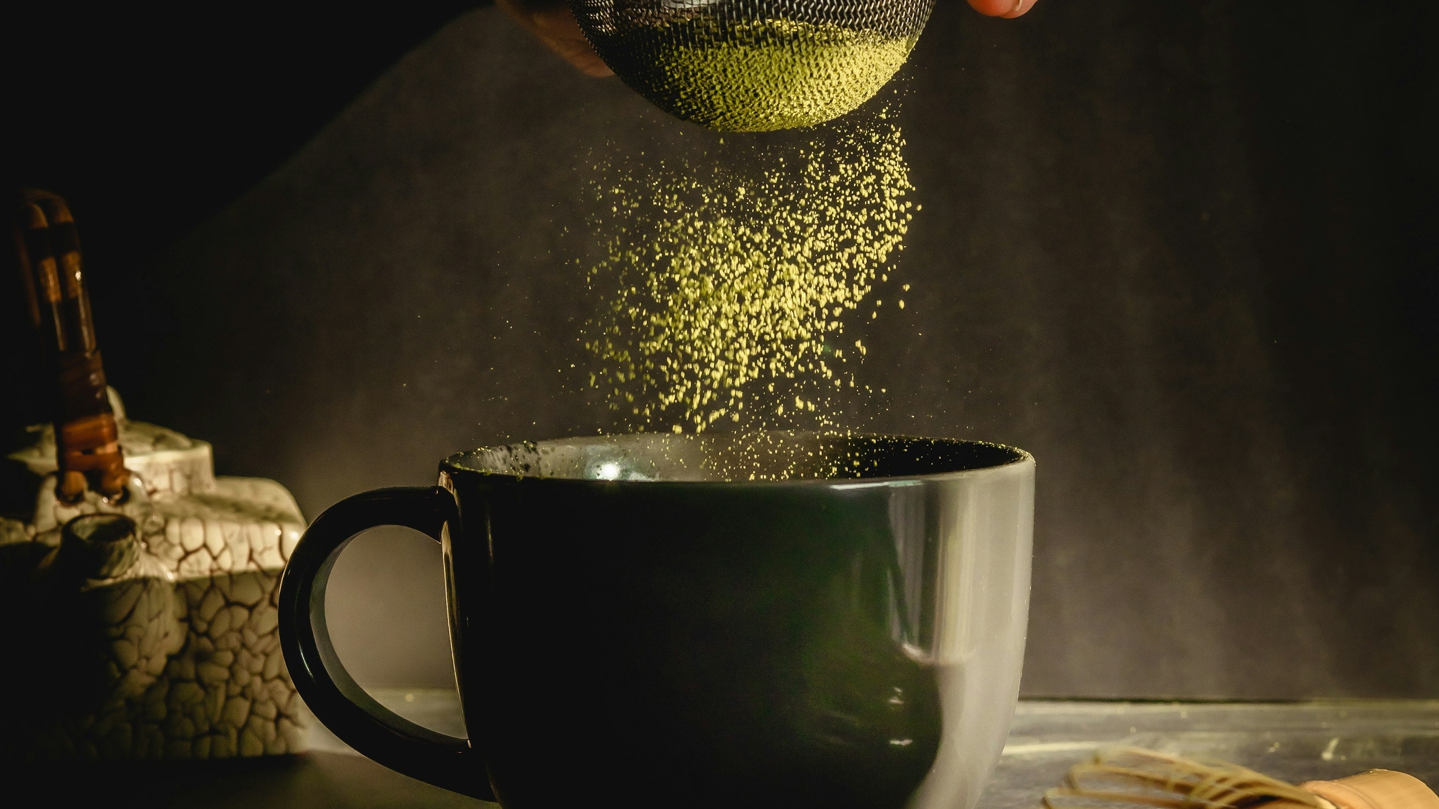 Matcha powder being sifted into a cup