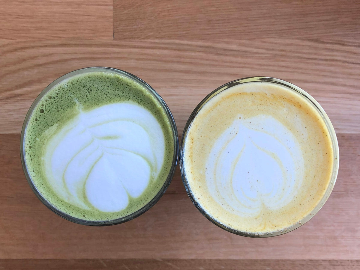 Two lattes poured with heart patterns